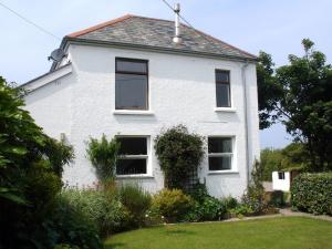 Cette maison blanche dispose de fenêtres et d'une cour. dans l'établissement Ley Park, à Welcombe