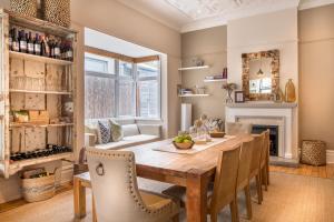 a dining room with a table and chairs and a fireplace at Antrim Villa Guesthouse in Cape Town