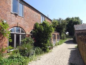 an old brick house with a pathway in front of it at Pittards Farm Cottage in Lambrook