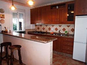 uma cozinha com armários de madeira e um frigorífico branco em La Almena em La Iruela