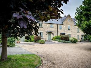 a large brick house with a gravel driveway at Stow Cottage in Stow on the Wold