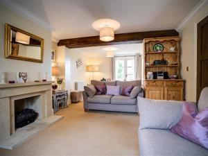 a living room with two couches and a fireplace at Stow Cottage in Stow on the Wold