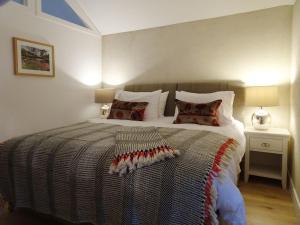 ein Schlafzimmer mit einem großen Bett und einer gestreiften Decke in der Unterkunft Rock View Cottage in Gunnislake