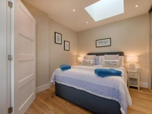 a bedroom with a large bed with blue pillows at Junket Studio in Newton Ferrers