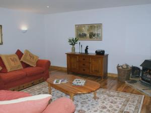 a living room with a red couch and a coffee table at Butterdon Barn in Moretonhampstead