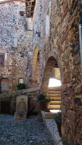 ein altes Steingebäude mit einer Treppe und einer Steinmauer in der Unterkunft Can Salgueda in Santa Pau