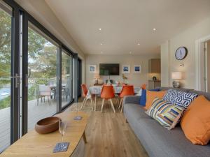 a living room with a couch and a dining room with a balcony at Junket Studio in Newton Ferrers