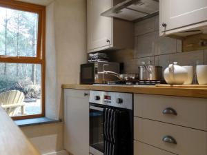 a kitchen with a stove top oven next to a window at Rock View Cottage in Gunnislake
