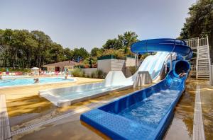 a water slide in a pool with a child on it at Camping Officiel Siblu Les Pierres Couchees in Saint-Brevin-les-Pins