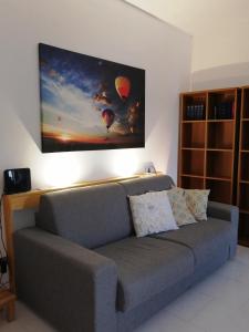 uma sala de estar com um sofá com um quadro na parede em A casa di Vince Monteaperti em Montaperti
