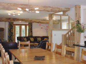 a dining room and living room with a wooden table at Swallows Reach in Halwell