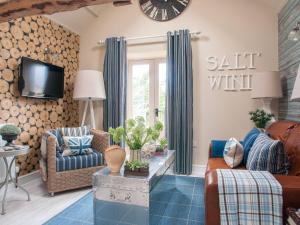 a living room with a couch and a clock on the wall at Saltwind Granary in Hartland