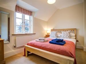 a bedroom with a large bed with a red blanket at Stow Cottage in Stow on the Wold