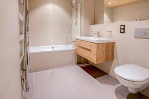 een badkamer met een toilet, een wastafel en een bad bij Les Roches Noires in Morzine
