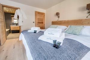 een slaapkamer met een bed met handdoeken erop bij Les Roches Noires in Morzine