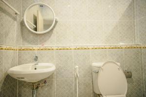 La salle de bains est pourvue de toilettes, d'un lavabo et d'un miroir. dans l'établissement Lullaby Residence, à Maha Sarakham