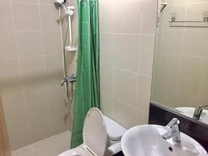 een badkamer met een toilet, een wastafel en een douche bij Modern Stylish Condo in Stamford McKinley Wi-Fi in Manilla