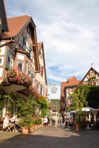 a group of people walking down a street with buildings at Berne's Altstadthotel in Besigheim