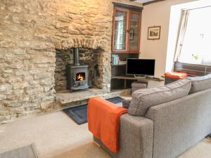 a living room with a couch and a stone fireplace at High View Cottage in Castleton