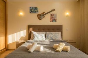 ラゴスにあるCasa das Palmeirasのベッドルーム1室(壁にギター付きのベッド1台付)