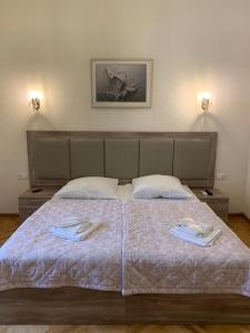 a bedroom with a bed with two towels on it at Guest House Rafael in Tbilisi City