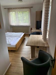 a bedroom with a bed and a table and chairs at Gästehaus Fries in Blankenheim