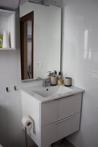 uma casa de banho branca com um lavatório e um espelho em centrico apartamento nuevo, zona corte ingles em Málaga