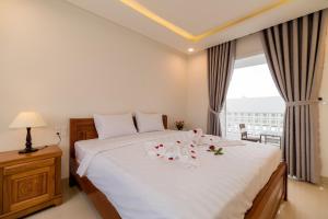 een slaapkamer met een wit bed met bloemen erop bij Chi Thanh Villa in Hội An