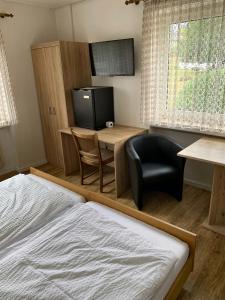 a bedroom with a bed and a desk and a chair at Gästehaus Fries in Blankenheim
