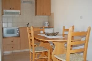 a kitchen with a table and chairs in a kitchen at Nicos & Olympia Apartments in Polis Chrysochous