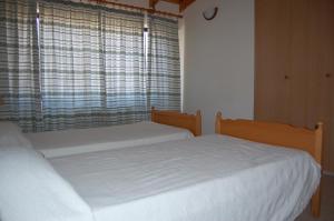 2 Einzelbetten in einem Schlafzimmer mit Fenster in der Unterkunft Nicos & Olympia Apartments in Polis Chrysochous