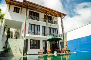 a villa with a swimming pool and a house at Villa Upper Dickson in Galle