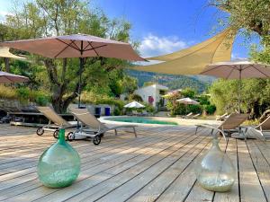 two glass bottles sitting on a wooden deck with umbrellas at Maison d'Hôtes Bleu Azur in Tourrettes-sur-Loup