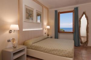 una camera con letto e finestra di Boutique Hotel Ilio a SantʼAndrea