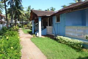ein blaues Haus mit Bürgersteig neben einem Hof in der Unterkunft O Camarao in Calangute