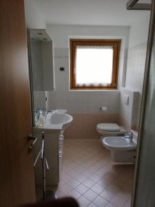 baño con 2 lavabos, aseo y ventana en Casa Laura en Valdidentro