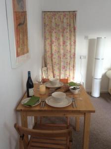 a wooden table with plates and a bottle of wine at Perfect for Caernarfon Castle, Snowdon, & Zip World in Caernarfon