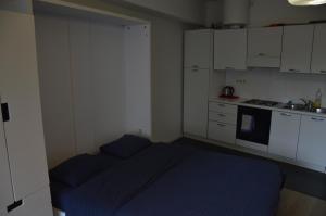 ブリュッセルにあるFlat Sympa next Grand Placeの小さなベッドルーム(青いベッド1台付)、キッチンが備わります。