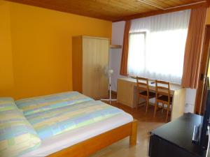 a bedroom with a bed and a desk and a window at Motel City in Spreitenbach