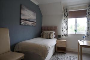 een kleine slaapkamer met een bed en een raam bij West View Lodge in Basingstoke