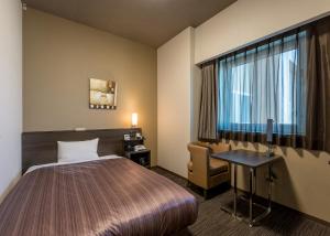 En eller flere senge i et værelse på Hotel Route Inn Grand Asahikawa Ekimae
