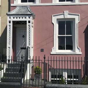 a pink building with a white door and a window at Perfect for Caernarfon Castle, Snowdon, & Zip World in Caernarfon