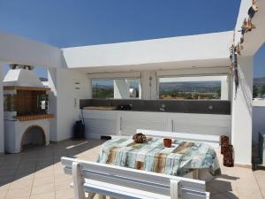 een slaapkamer met een tafel en een keuken met ramen bij Sea Breeze Villa in Charaki