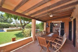 an outdoor patio with a wooden table and chairs at Finca Siscelis 063 by Mallorca Charme in Santa Maria del Camí