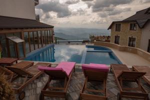 uma piscina com cadeiras e uma piscina em K19 Milmari Resort & Spa em Kopaonik