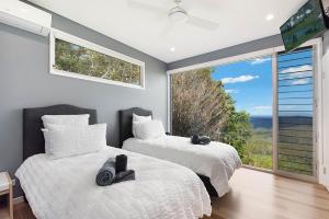 two beds in a room with a large window at 629 Balmoral Ridge in Balmoral Ridge