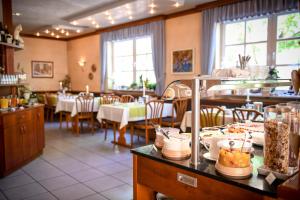 Hotel Mainblick Garni في ماركت هايدنفلد: مطعم بطاولات وكراسي مع طعام على كاونتر