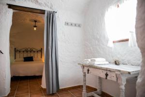 Un dormitorio con una cama y una mesa en una habitación. en Casas Cueva Molino Fuencaliente, en Huéscar 37 fotos más