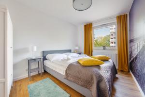 a bedroom with a bed with a clock on the wall at Apartamenty Sun & Snow Wyspa Solna in Kołobrzeg