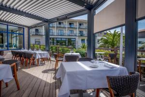 a restaurant with tables and chairs and a building at Thalazur Arcachon in Arcachon